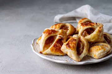 homemade puff pastry cookies with yellow plum on a round plate o
