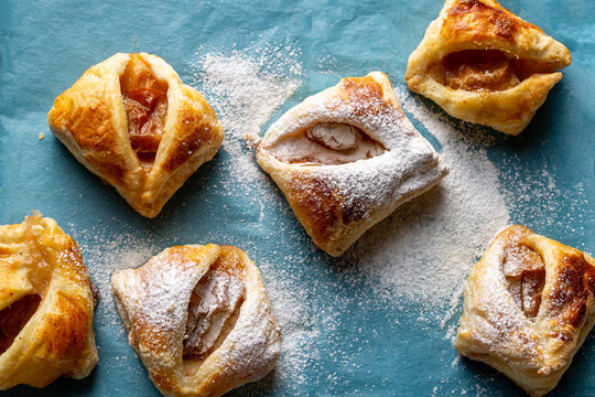 Puff Pastry Cookies With Frozen Plums On Blue Paper