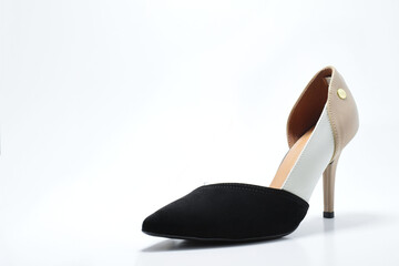 Zapato de tacón para mujer color beige y negro. Calzado formal para fiesta o trabajo sobre un fondo blanco, espacio para texto al lado izquierdo.
