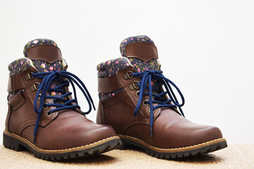 Botas cafés de senderismo para mujer. Calzado para aventura sobre un fondo blanco con espacio para...