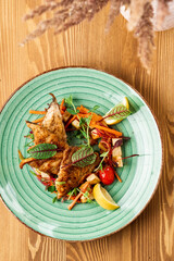 grilled fish with a side dish on a wooden background. Restaurant