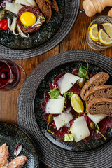 marble beef carpaccio with herbs, rye bread and sauce