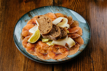 salmon carpaccio with herbs, rye bread and sauce