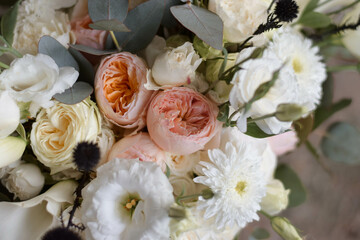 Modern bridal bouquet made from roses, freesia, eustoma and eucalyptus on dark background.