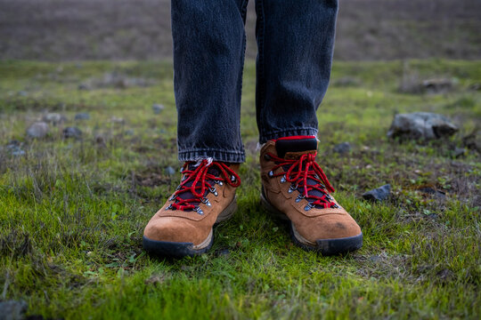 Detail of hiking boots in green grass on cold damp morning