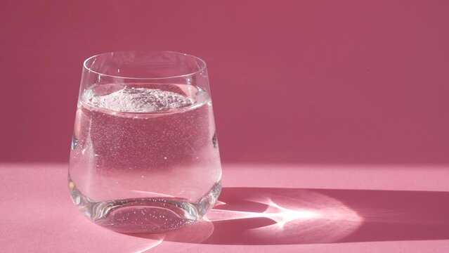 Adding collagen powder in a glass of water. Superfood additives. Slow motion.