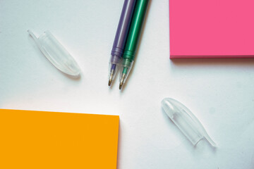 Color sticky note paper sheets with small hearts. Closeup on old wooden table.