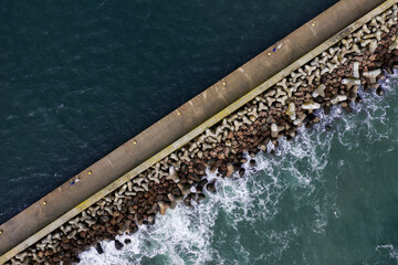 Aerial view of a stone breakwater on the port