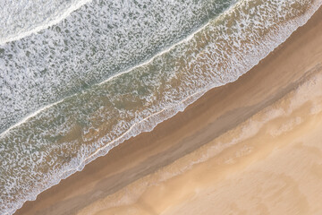 Aerial view of waves crash to beach