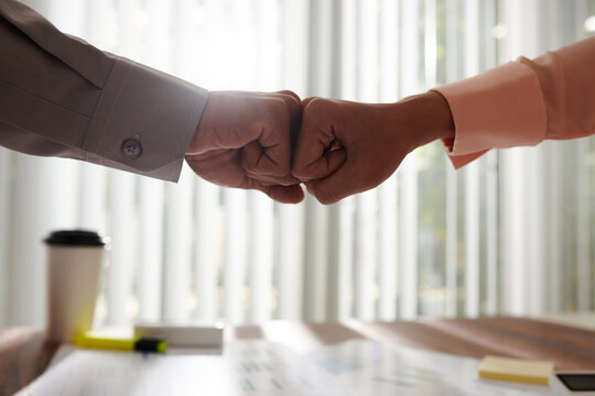 Business people giving each other fist bump to express trust, support and partnership