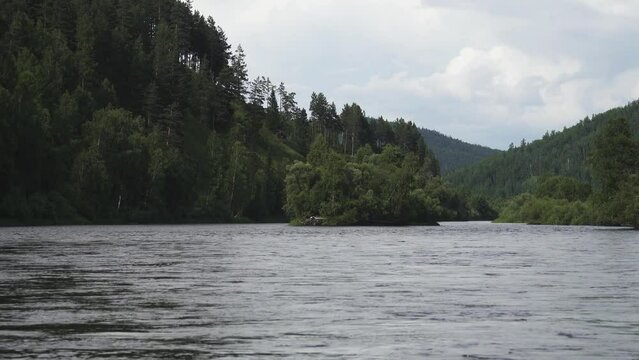 Middle Siberia, Krasnoyarsk Territory. Hilly (coniform hill) river bank, water flow. Taiga mixed forests
