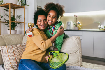 Proud mother feel so excited to see her daughter medal and trophy in her hand after tennis tournament.