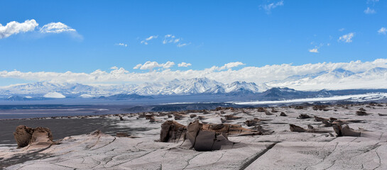 Panoramic view of multiform rocks of pumice with a chain of volcanic mountains in the background,...
