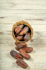 close up picture of dates palm fruit in cup on wooden table background. Dates palm fruit dry is snack healthy.