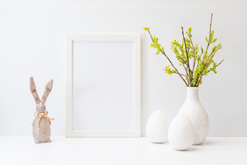 Home interior with easter decor. Mockup with a white frame and willow branches in a vase, easter...
