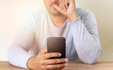 Man holding smartphone and beating his nails due to stress, anxiety and worried.
