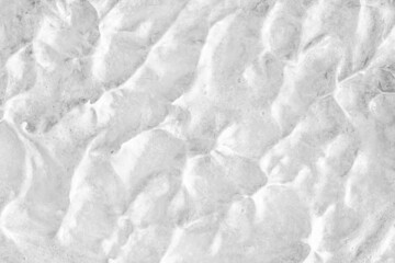 White cream texture. Surface of yogurt and a smoothie of whipped cream smoothie. Background texture of masks and scrubs for face and body. Pearlescent silver surface of the foam.