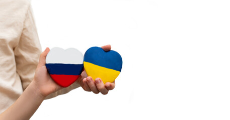 Ukrainian and Russian flags in shape of heart are in hands of children. Close up. Copy space.