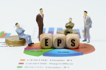 On financial reports with diagrams, figures of businessmen and wooden cubes with the inscription -...