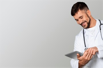 Beautiful doctor or nurse holding a tablet computer and posing
