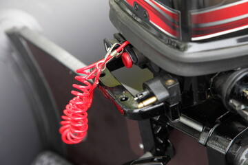 Safety engine stop swich with red rope on outboard motor. Safety on boat use.