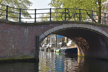 Fototapeta premium A bicycle is parked on a bridge over a canal in Amsterdam.