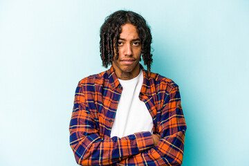 Young African American man isolated on blue background unhappy looking in camera with sarcastic expression.