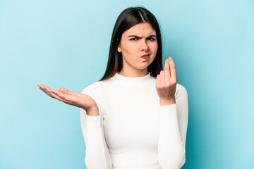 Young caucasian woman isolated on blue background showing that she has no money.