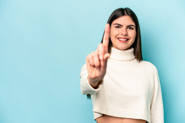 Fototapeta premium Young caucasian woman isolated on blue background showing number one with finger.