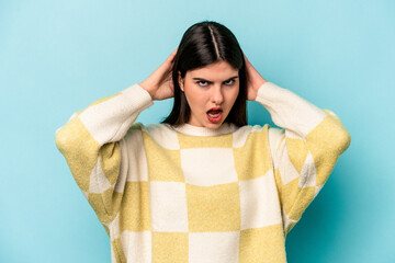 Young caucasian woman isolated on blue background screaming, very excited, passionate, satisfied...