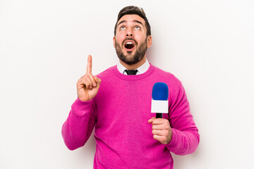 Young caucasian tv presenter man isolated on white background pointing upside with opened mouth.