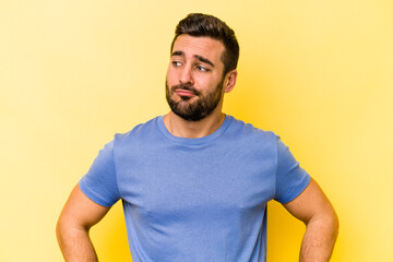 Fototapeta premium Young caucasian man isolated on yellow background confused, feels doubtful and unsure.