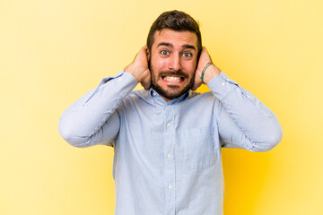 Young caucasian man isolated on yellow background screaming with rage.