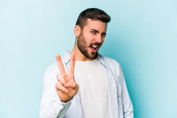 Young caucasian man isolated on blue background showing number two with fingers.