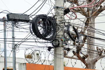 Many electrical cable - wire and telephone line on electricity post.  Tangle of cables and wires.
