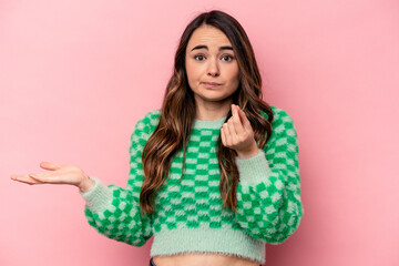 Young caucasian woman isolated on pink background showing that she has no money.