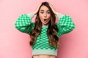Young caucasian woman isolated on pink background being shocked, she has remembered important...