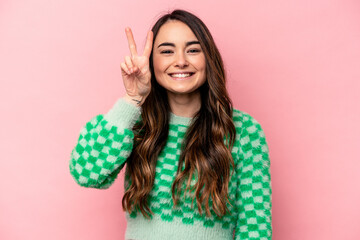 Young caucasian woman isolated on pink background showing number two with fingers.