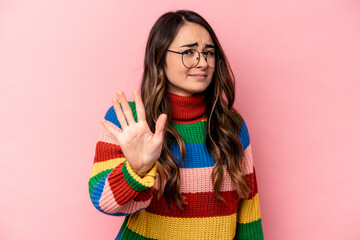 Young caucasian woman isolated on pink background rejecting someone showing a gesture of disgust.