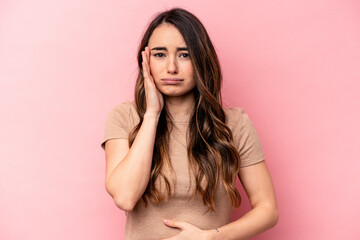 Young caucasian woman isolated on pink background blows cheeks, has tired expression. Facial...