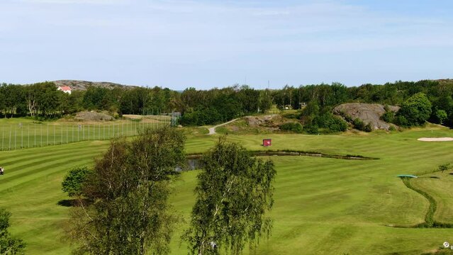 Drone flying over golf course with breathtaking panorama in background, Molndal near Gothenburg in Sweden. Aerial forward ascending