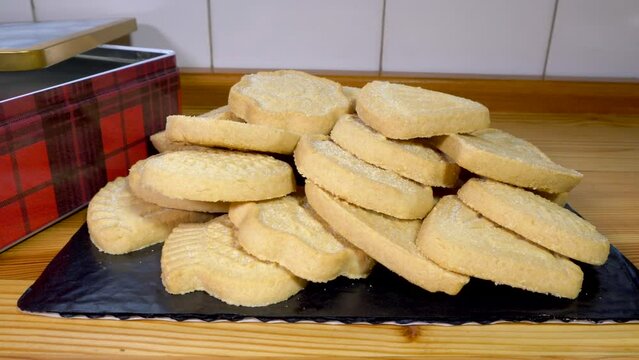 Closeup dolly shot of the contents of a product tin box of all butter Scottish shortbread assortment, in a pile.