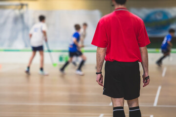 View of floorball match game, court hall indoor venue with junior teenage children school team...