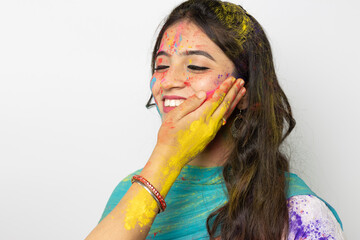 Holi colour powder being applied by a woman on Young indian smart girl face for festival of colours Holi, a popular hindu festival celebrated across india, isolated over white background