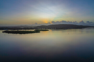 Fototapeta na wymiar Hazy Sunrise Waterscape with Reflections