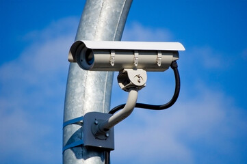 City monitoring system camera against blue sky.