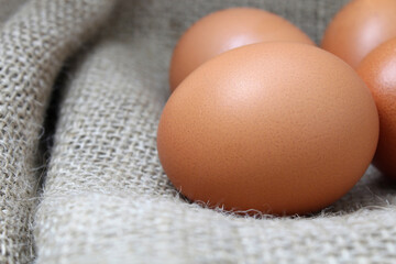 fresh brown chicken eggs lie on burlap