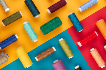 Bright multicolored background with spools of sewing thread. Top view, copy space. Beautiful...