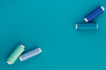 Blue thread. A set of spools of sewing thread. Several spools of thread in different shades of blue on a blue background. Top view