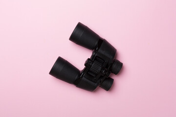 Black binoculars on color background. Top view